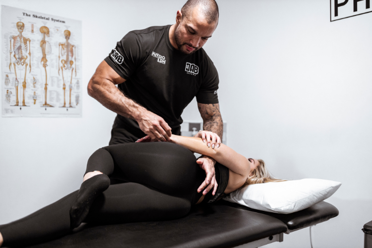 Physiotherapist performing spinal adjustment for female patient
