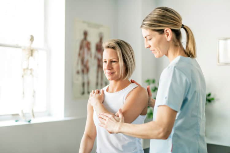 Physiotherapist guiding shoulder rehab for improved mobility - One Body LDN Physiotherapist guiding shoulder rehab for improved mobility