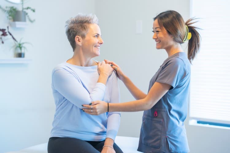 Smiling patient during preventive physiotherapy shoulder assessment - One Body LDN Smiling patient during preventive physiotherapy shoulder assessment