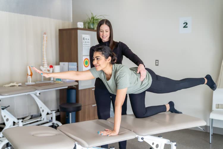 Woman practicing core stability with physiotherapists guidance - One Body LDN Woman practicing core stability with physiotherapist’s guidance