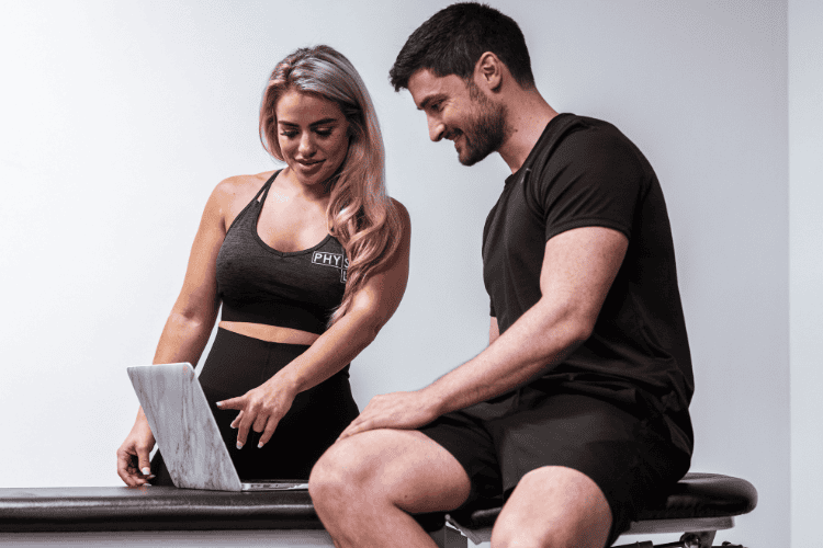 Physiotherapist chatting with patient while reviewing progress online
