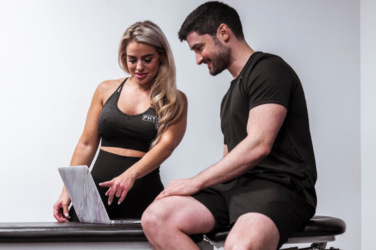 Physiotherapist chatting with patient while reviewing progress online