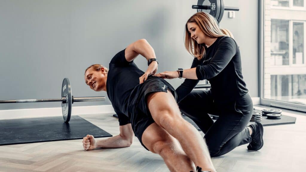 Physiotherapist guiding side plank exercise to improve core strength
