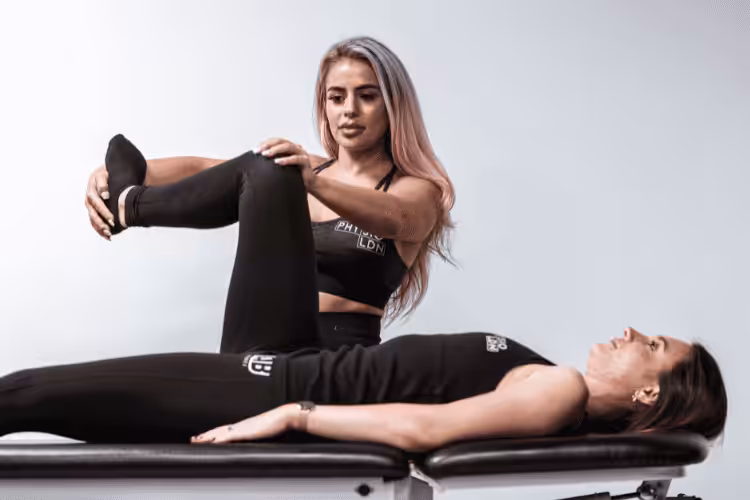 Physiotherapist supporting knee mobility therapy for female patient