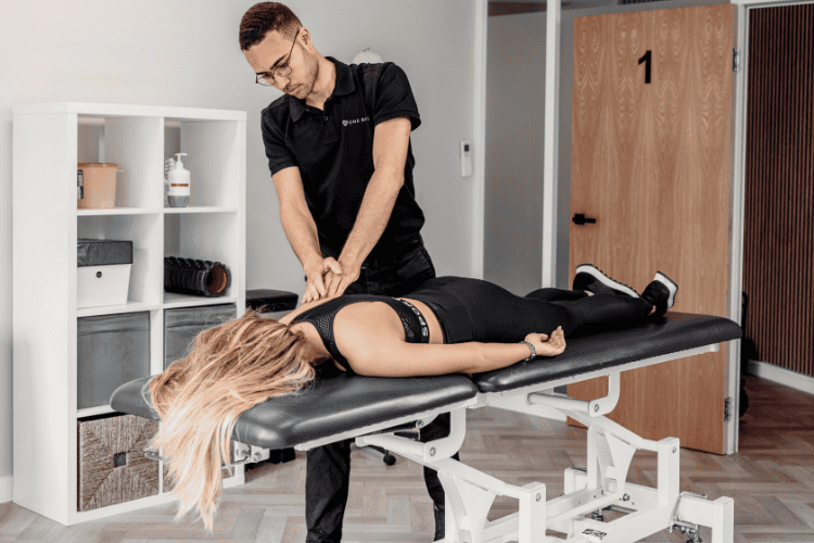 Physiotherapist providing sports massage therapy for back pain