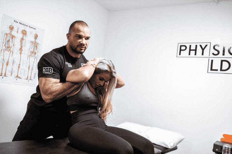 Physiotherapist performing spinal adjustment on female patient