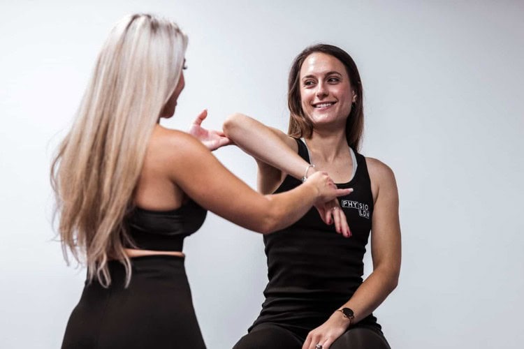1 One Body LDN therapist guiding patient through hand mobility therapy - One Body LDN One Body LDN therapist guiding patient through hand mobility therapy