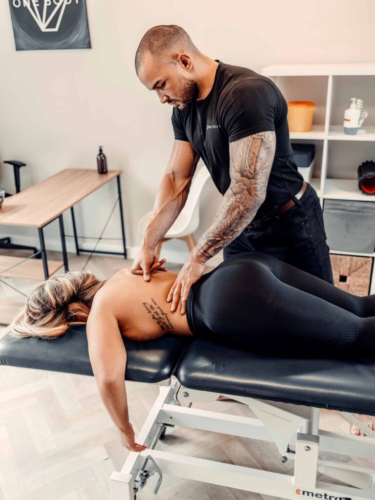 Sports massage therapist treating client at One Body LDN clinic