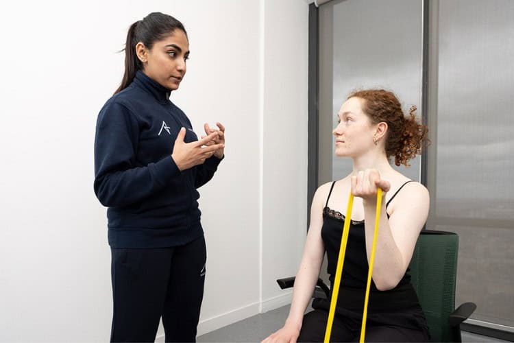 Ascenti Physiotherapy guiding patient through resistance band exercise
