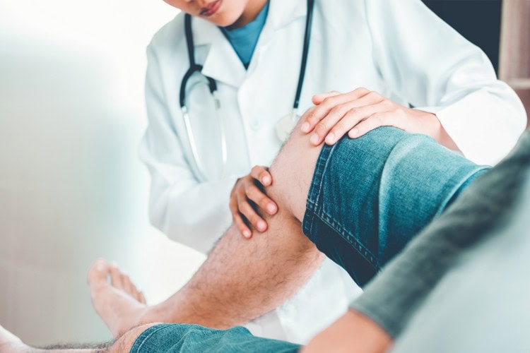 Doctor examining patients knee at London Orthopaedic Clinic