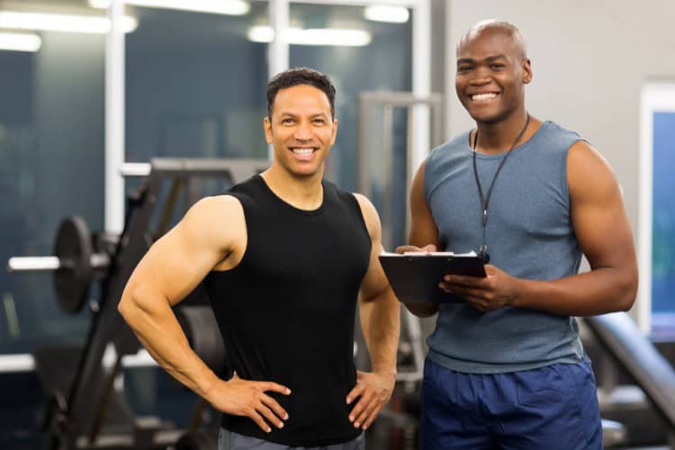Active lifestyle athletes and coach posing confidently in gym - One Body LDN Active lifestyle athletes and coach posing confidently in gym