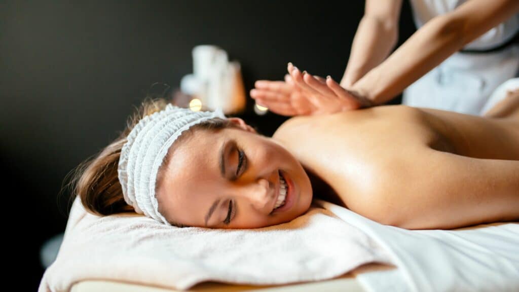 Smiling woman enjoying relaxing sports massage therapy session