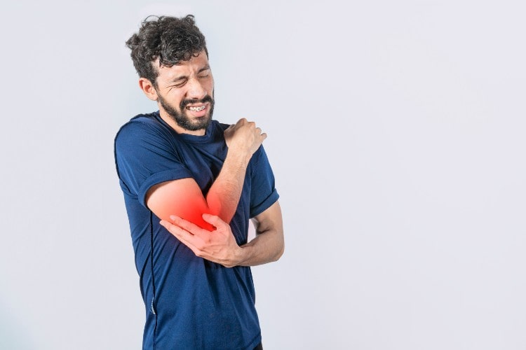 Man in pain from trapped nerve in elbow - One Body LDN Man in pain from trapped nerve in elbow