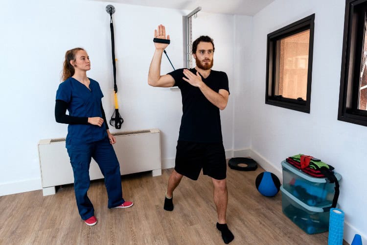 Physiotherapist assessing patient’s shoulder mobility with resistance band