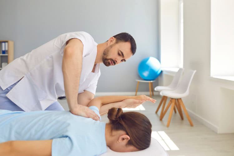 Physiotherapist treating patients shoulder pain with manual therapy - One Body LDN Physiotherapist treating patient’s shoulder pain with manual therapy