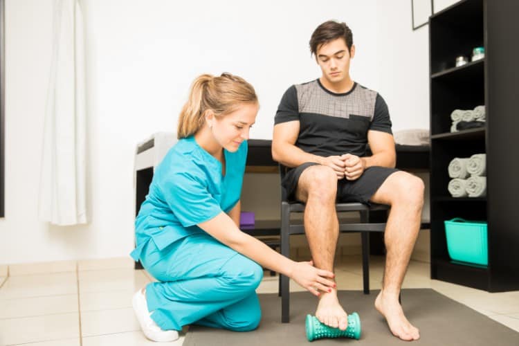 Physiotherapist treating plantar fasciitis with foot roller therapy session
