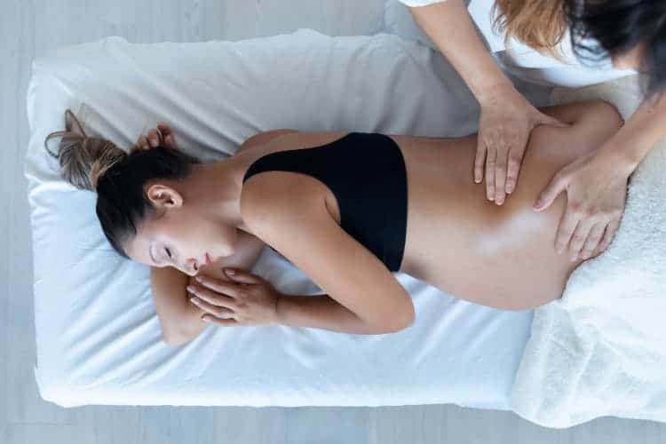 Pregnant woman receiving gentle massage with relaxation and care