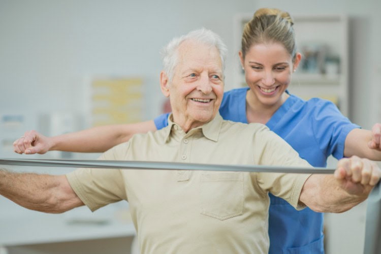 Smiling senior receiving quality physiotherapy support with resistance training