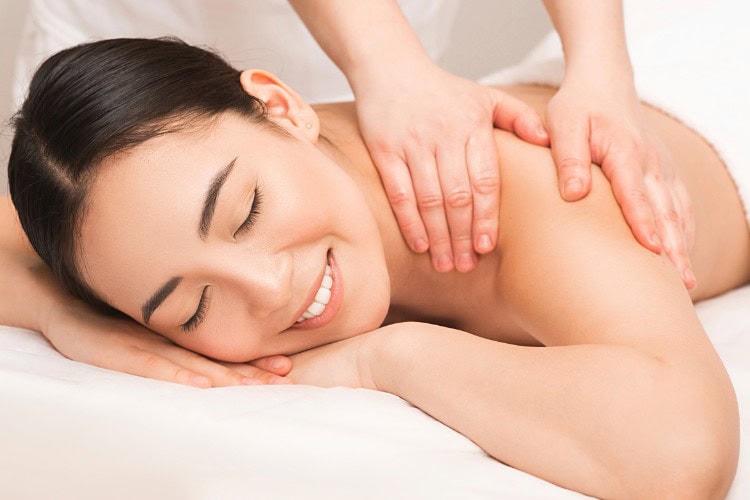 Smiling woman receiving upper back sports massage therapy - One Body LDN Smiling woman receiving upper back sports massage therapy