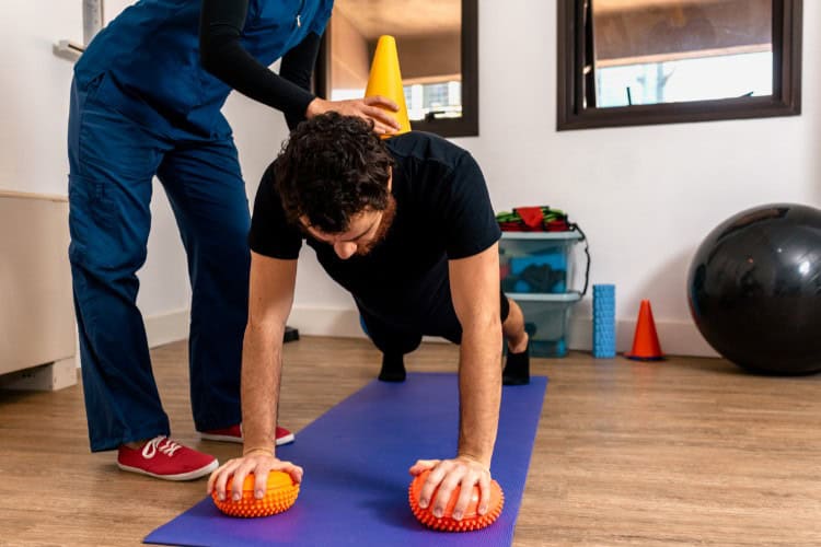 Sports physiotherapist assisting core stability exercise with balance tools
