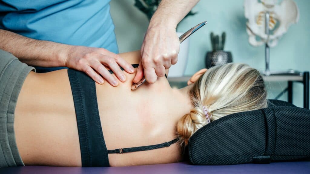 Therapist using advanced tool-assisted deep tissue massage technique Physiotherapy in London