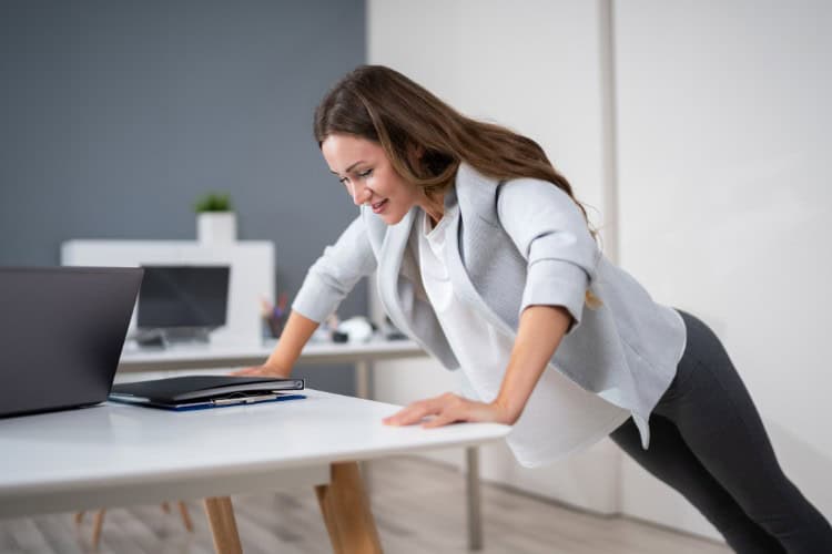 What a Tailored Workplace Programme Looks Like - One Body LDN Office worker doing desk push-ups during wellness program