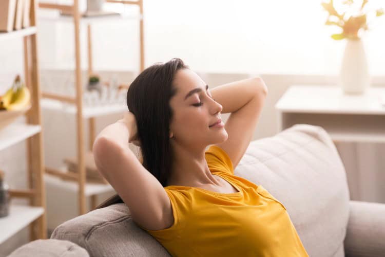 Woman feeling relaxed at home after deep tissue massage - One Body LDN Woman feeling relaxed at home after deep tissue massage