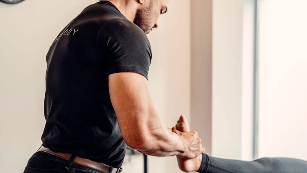 Professional physical therapist treats a patient's ankle