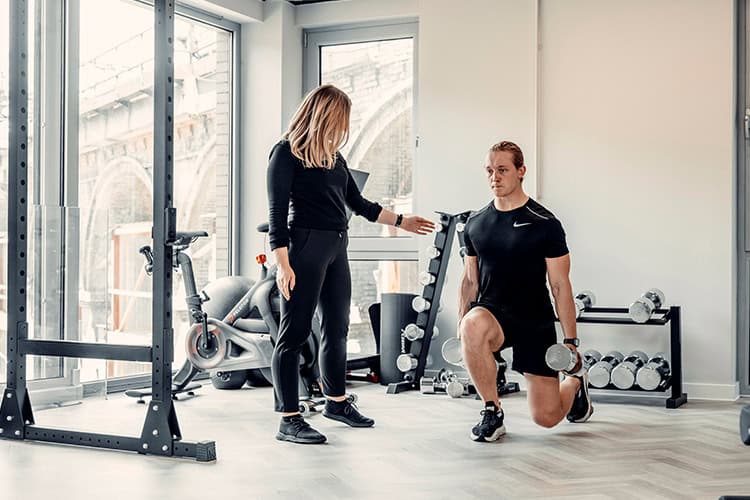 Professional female physiotherapist helping a male patient exercise