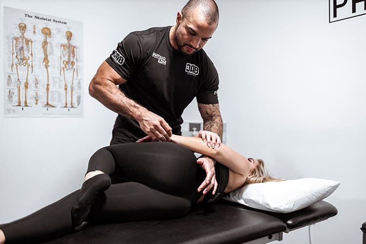 Male physical therapist treats a female patient's hip pain