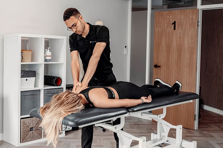 Professional male sports massage therapist treating a patient