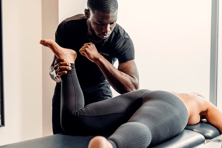 Physiotherapist stretching a patient’s hip on a treatment table – guided hip therapy session