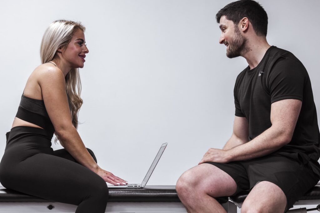 Physiotherapist chatting with patient while reviewing progress online