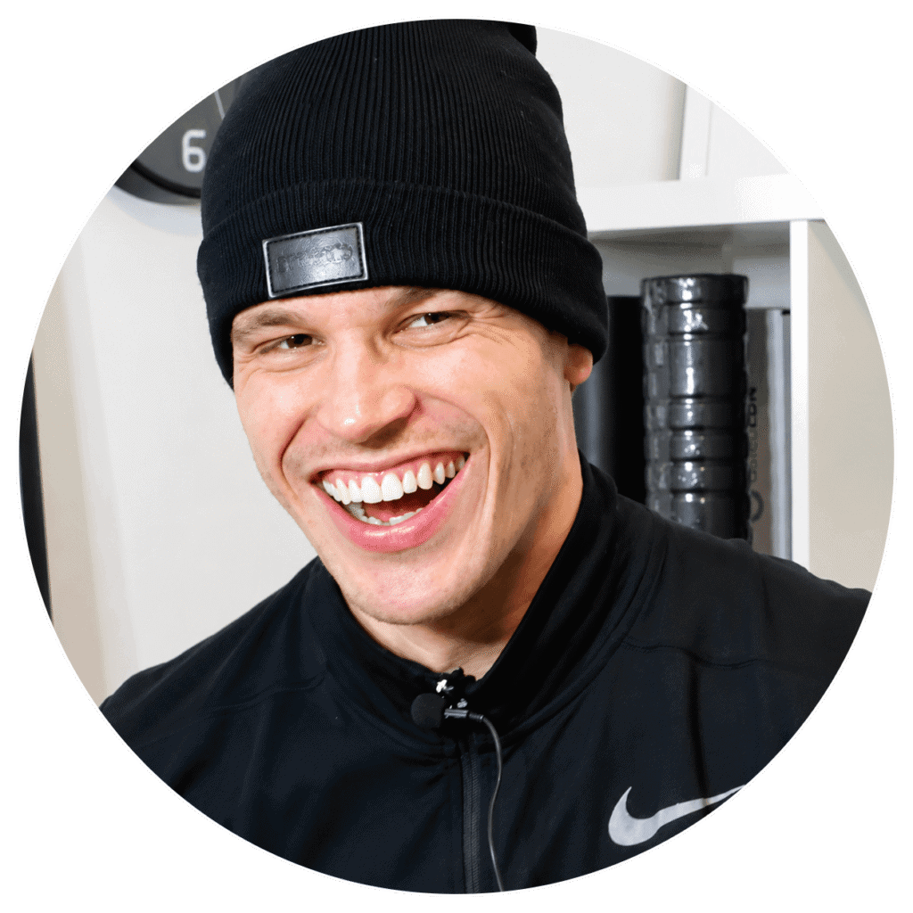 Smiling man in black beanie and sportswear at physiotherapy clinic.